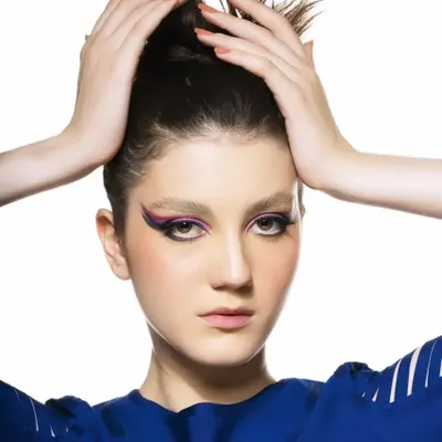 A perfect example of clean, graphic makeup. The sharp, extended purple eyeliner creates a powerful and modern look for this high-fashion portrait.