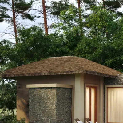 The exterior of a private cottage at Dev Villas, Kanha. The design uses a combination of local stone and a traditional pitched roof made from sustainable materials to integrate the structure into its forest setting.