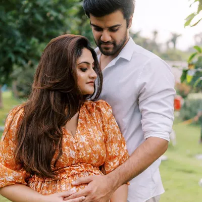 A classic and romantic outdoor maternity portrait. The way he holds her from behind in this beautiful green space feels both protective and loving, a perfect representation of their partnership.