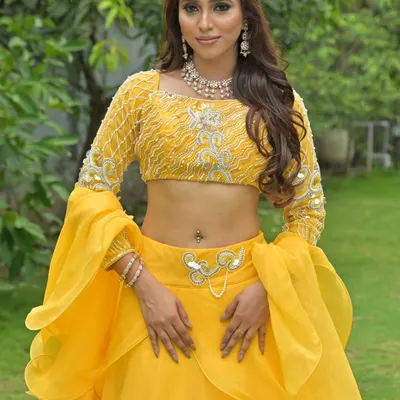 A vibrant yellow lehenga with flared sleeves, perfect for a Haldi or Mehendi ceremony. The look is completed with a delicate diamond necklace and matching earrings.