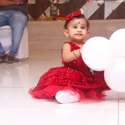 Candid photography from a first birthday party. I focus on capturing the genuine moments of wonder and fun, like this little one with her balloons, so you can enjoy the celebration.