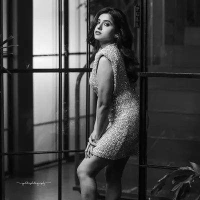 A striking black and white portrait of an actress in a glitter dress. The monochrome treatment emphasizes her pose and expression, creating a dramatic and high-fashion feel.