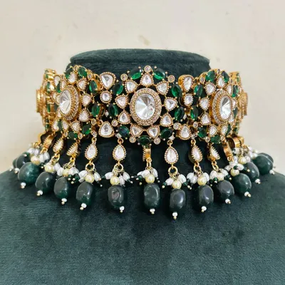 A beautiful bridal choker with green stones and American diamond accents. The dangling green beads add movement to this rental piece.