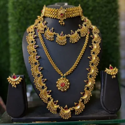 A classic temple jewellery set with a crescent motif, featuring a choker, a long necklace, and matching earrings.