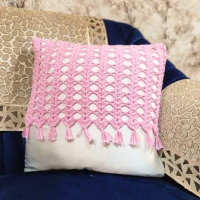 A pretty pink cushion cover to make your sofa look beautiful. I made this with a lovely mesh pattern and added small tassels on the bottom. It is made from 100% cotton yarn, so it is very soft. 🥰