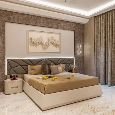 This master bedroom features a sophisticated palette of beige and brown, with a custom geometric headboard and integrated ambient lighting. The textured wallpaper behind the bed adds depth and a touch of opulence.