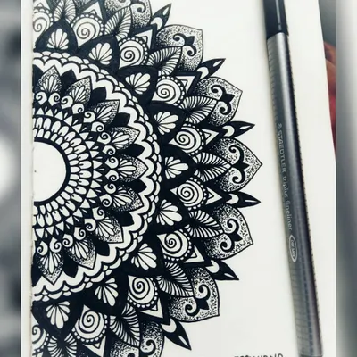 A semi-circle mandala drawn in my sketchbook. Making mandalas is a form of meditation for me, helping me concentrate and find peace.