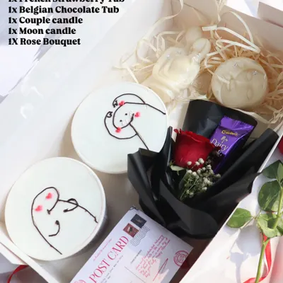 "The Love Story" hamper for Valentine's Day. It includes two dessert tubs with cute drawings, couple and moon-shaped candles, and a rose bouquet.