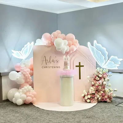 A beautiful christening adorned with nature's gentle touch. This setup uses soft peach hues, glowing butterfly whispers, and floral blossoms to create a serene and elegant atmosphere for a blessed day.