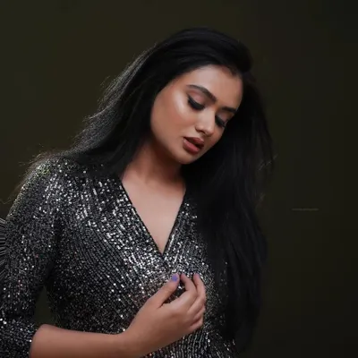 A moody and glamorous shot for a model's portfolio. The single-source lighting highlights the texture of the sequined dress while casting soft shadows, creating a sophisticated look.