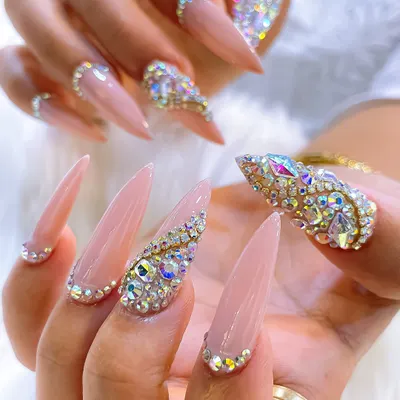 An absolutely stunning example of high-glamour nail art. This set features long, nude stiletto nails with a heavy encrusting of Swarovski crystals in various shapes and sizes.
