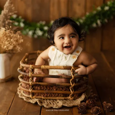 A perfect sitter session moment! This baby's joyful giggle in our rustic basket setup is what these milestone photos are all about.