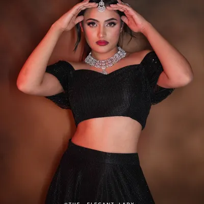 A bold and dramatic pose showcasing a stunning diamond-look necklace and maang tikka. This set is perfect for making a statement at a reception or cocktail party.