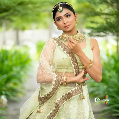 An elegant portrait in a light green lehenga. The soft, natural light and the model's graceful pose create a serene and beautiful image.