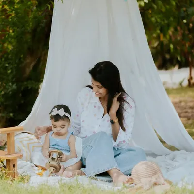 A quiet moment between a mother and her baby during an outdoor picnic session. The peaceful setting is perfect for capturing these gentle interactions.