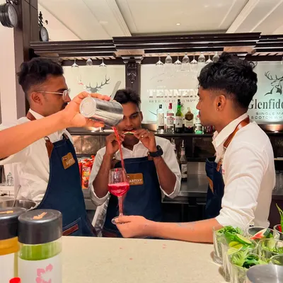 Our students collaborating to perfect a tandem pour. We emphasize teamwork and peer learning in our intensive bartender training programs.