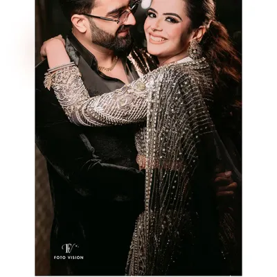 A warm and happy embrace between the couple, their smiles lighting up the frame, showcasing their effortless chemistry.