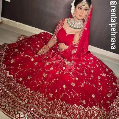 A classic red velvet bridal lehenga with heavy gold embroidery along the border. This is a timeless choice for a traditional Hindu wedding ceremony.
