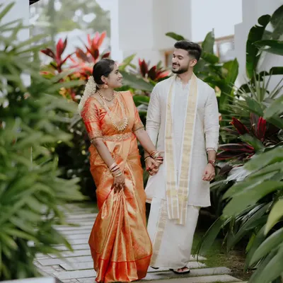 A South Indian couple takes a serene walk together, dressed in a beautiful Kanjeevaram saree and traditional mundu. I capture these quiet moments of connection amidst the wedding day buzz.