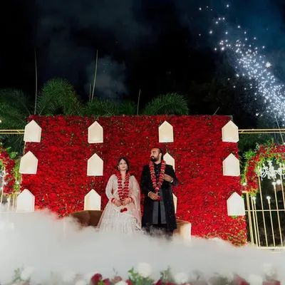 A truly spectacular reception stage with a wall of red roses, dramatic smoke, and fireworks. We use our expertise in lighting and composition to capture the grandeur of your celebration.