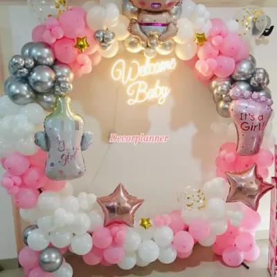 A perfect circle of joy to welcome a new baby. This beautiful balloon ring in pink, white, and silver, complete with a "Welcome Baby" neon sign, creates a stunning centerpiece for a homecoming celebration.