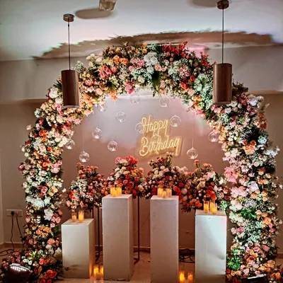 This magnificent floral arch was the centerpiece for a birthday celebration. It is filled with a variety of flowers in shades of pink, peach, and white, creating a beautiful frame for photos.