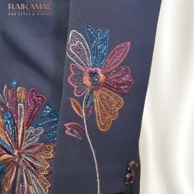 This is a detail of the sleeve on a modern Indo-Western jacket. The vibrant, multi-colored floral threadwork stands out against the dark fabric, offering a contemporary twist on traditional embroidery for a stylish fusion look.