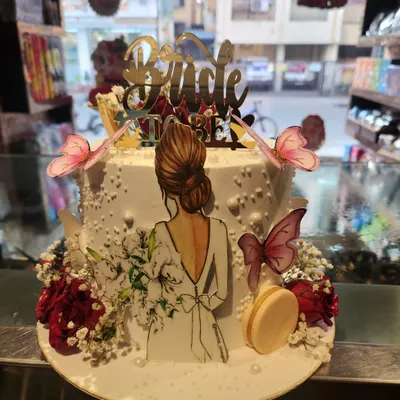 A beautiful and modern 'Bride to Be' cake. This design features an elegant illustration of a bride, delicate wafer paper butterflies, and fresh flowers.