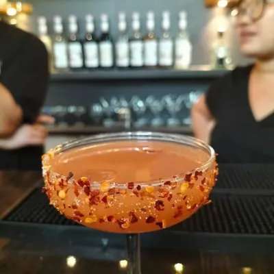 A spicy twist on a classic. This cocktail features a chili flake rim, adding a kick of heat that perfectly complements the drink's flavor profile.