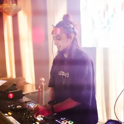 A focused moment at the DJ console, surrounded by a hazy glow. Here, I'm lining up the next track on my Pioneer setup.