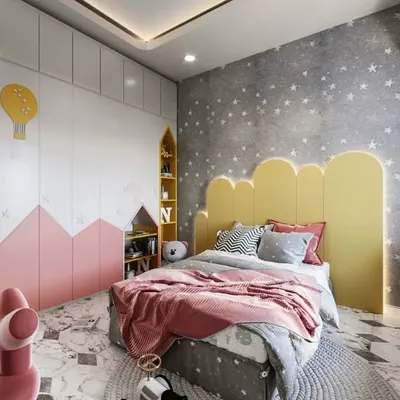 A dreamy bedroom design featuring a cloud-shaped headboard with accent lighting. The room combines soft pink and bright yellow with a starry wallpaper and mountain-themed wardrobe to create a whimsical landscape.