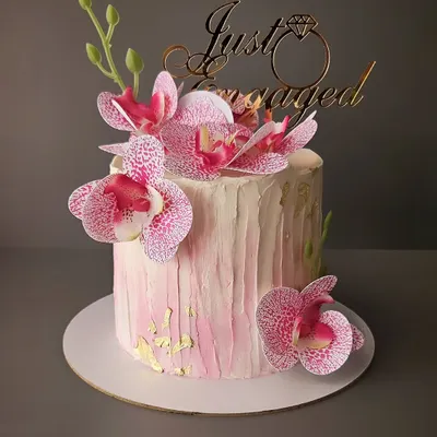 A beautiful pink orchid cake for an engagement. This buttercream cake is decorated with delicate wafer paper orchids and gold leaf accents for a touch of elegance.