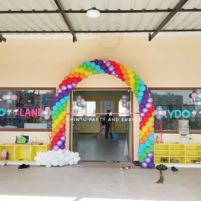 A welcoming rainbow balloon arch for a playschool entrance. This colorful decoration is perfect for school openings, annual days, or children's events.