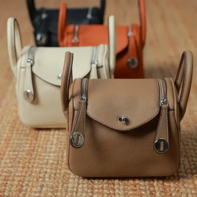 All the beautiful colours of the Linde Medium and Large bags together. You can see the taupe, off-white, ginger brown, and black options, each with elegant silver hardware.
