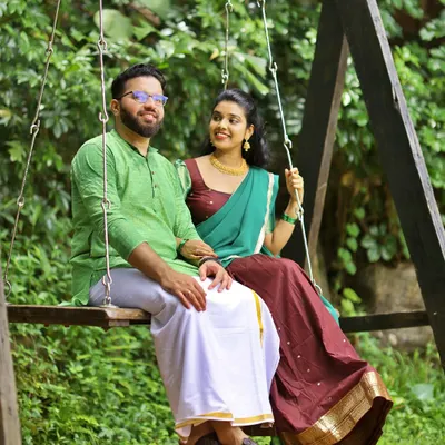 A relaxed and natural shot of a couple on a wooden swing, set in a lush green garden. A perfect example of our candid pre-wedding photography.