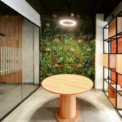A vibrant green wall serves as the focal point in this modern office, showcasing our biophilic design approach. We integrate natural elements like this to create a refreshing and productive atmosphere that reduces stress and improves well-being for the team.