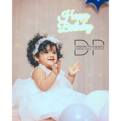 Capturing the pure delight of a first birthday. This little girl's happy claps and bright smile made for a perfect portrait.