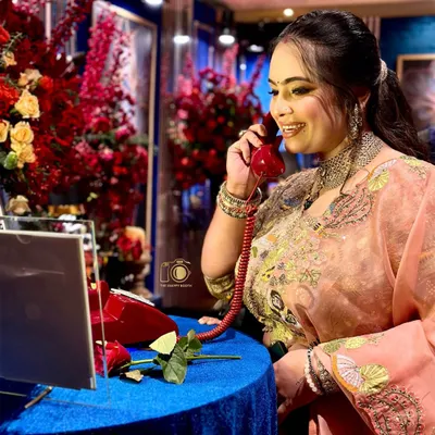 A perfect match for a glamorous event. A guest enjoys leaving a message on the Retro Red phone, surrounded by lush floral arrangements that create a truly luxurious and photogenic corner at your reception.