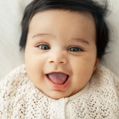 A perfect, joyful baby smile. This close-up shot is all about capturing that infectious happiness that can light up a whole room.