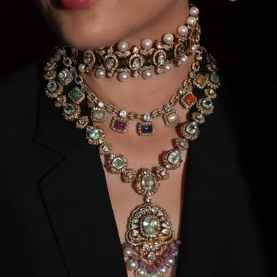 If your jewellery could have a main character moment, it would be Navratan. This close-up shows a layered stack of Navratan necklaces, showcasing the nine powerful gems.