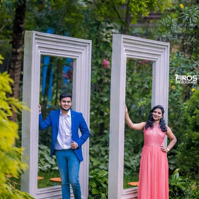 A fun and playful shot using the giant frame props. The couple's bright, casual outfits and happy expressions make for a cheerful and modern pre-wedding portrait.