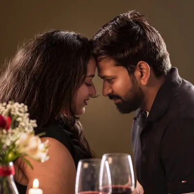 A romantic, candlelit moment for a couple. This photo captures the intimacy and love shared between two people, perfect for an anniversary celebration.
