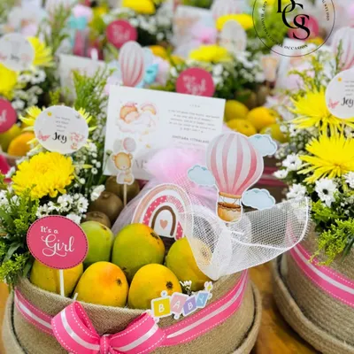 Announcing the arrival of a baby girl with these beautiful and healthy fruit hampers. Each jute basket is filled with fresh fruits and flowers, decorated with pink ribbons and "It's a Girl" tags.