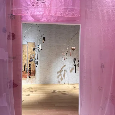 An entrance into the 'Feel More' installation, where layers of translucent pink fabric create a soft, ethereal threshold. The hand-printed patterns whisper stories of nature's simplicity.