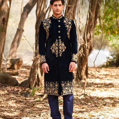 This is pure royalty. A deep navy velvet sherwani with intricate gold embroidery on the shoulders, cuffs, and hem. It’s a powerful, regal look for a groom who wants to command attention at his wedding or reception.
