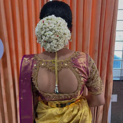 A close-up of a classic South Indian kondai, or bun, completely covered in fresh jasmine flowers. This is a timeless and fragrant choice for a traditional ceremony.
