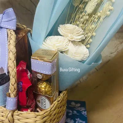 A close-up of a romantic birthday hamper for a fiancée. It includes her favorite white dried flowers, Ferrero Rocher chocolates, and other treats in a beautiful jute basket.