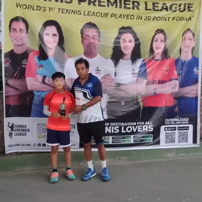One of our junior champions receiving his winner's trophy from our coach at the TPL-ITA Tennis Tournament. Celebrating success is a big part of our academy's culture.