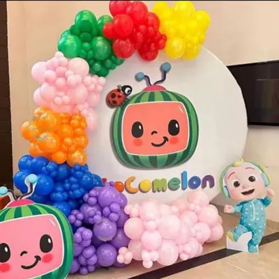 A vibrant Cocomelon themed decoration. This setup features a large circular backdrop with the Cocomelon logo, character cutouts, and a colorful balloon garland that mimics the show's bright and cheerful aesthetic.