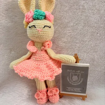 This sweet 10-inch bunny is dressed in a pink ballerina-style dress and has a floral bow. She is made with baby-safe cotton yarn.